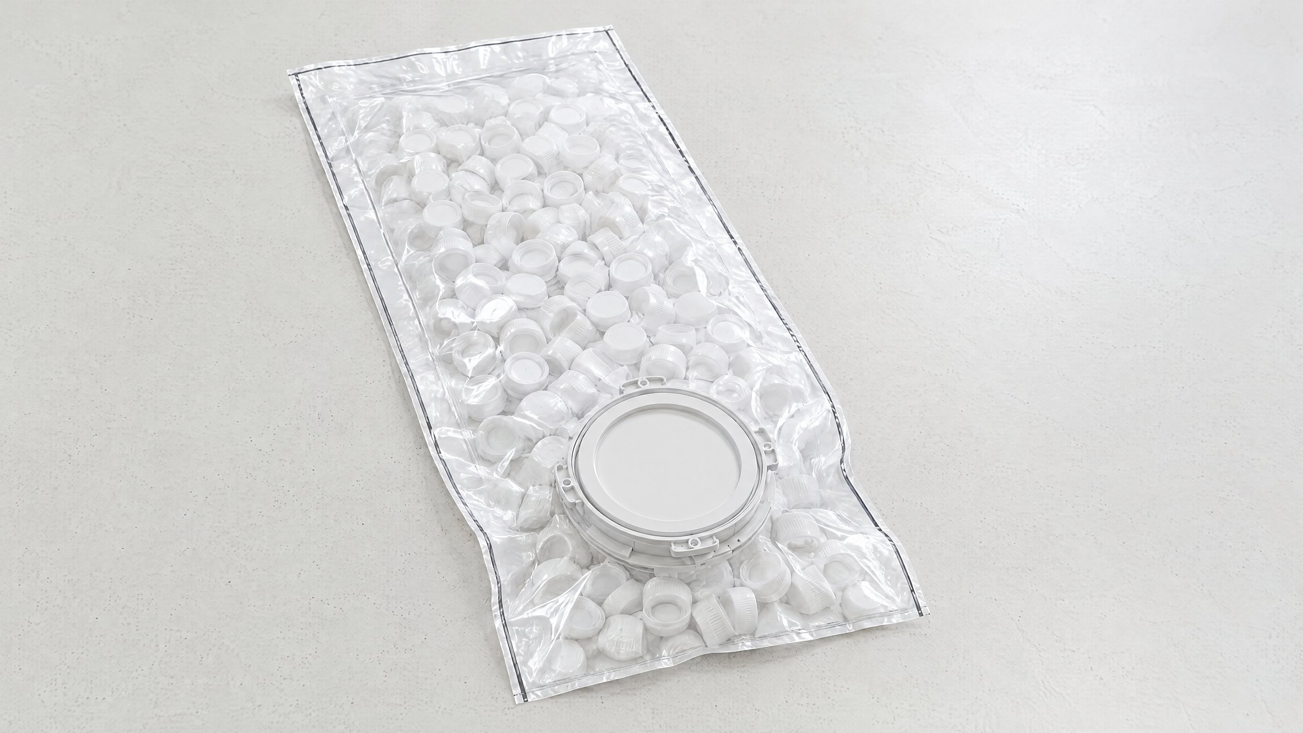 A Pre-loaded DELTAQUANT single-use beta bag filled with twist-off ports, lying flat on a pale table: a flat pouch with the 190 mm beta flange sandwiched into its face, the flange cover facing up.